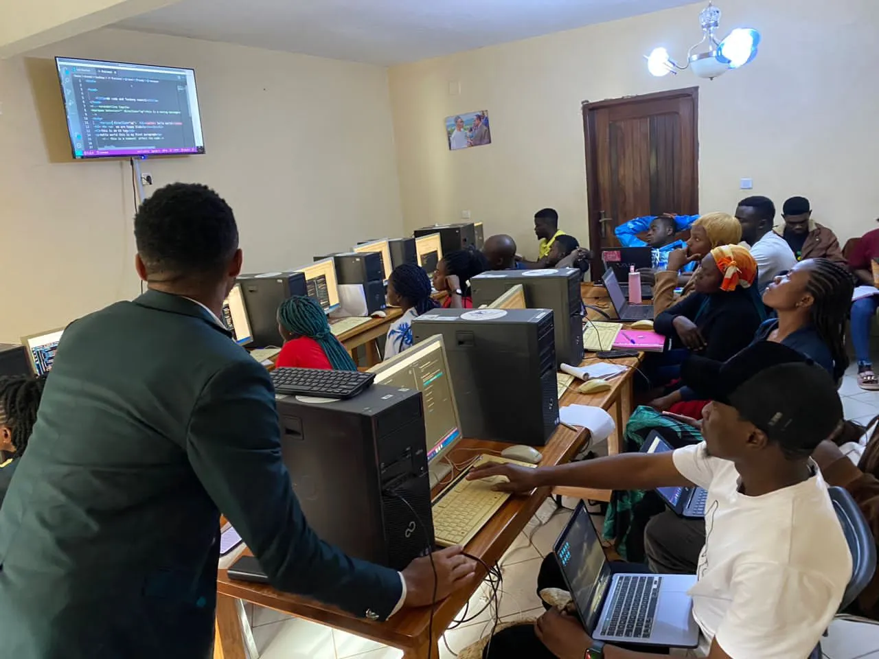 Nsom Emmanuel teaching trainees at computers in Fundong