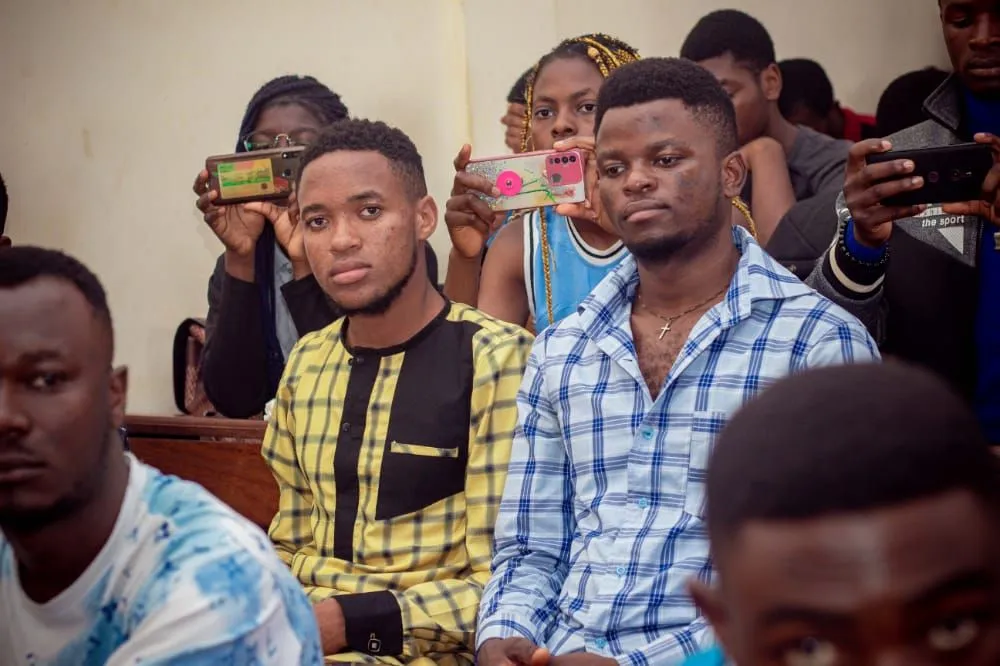 Nsom Emmanuel seated in an audience at an event